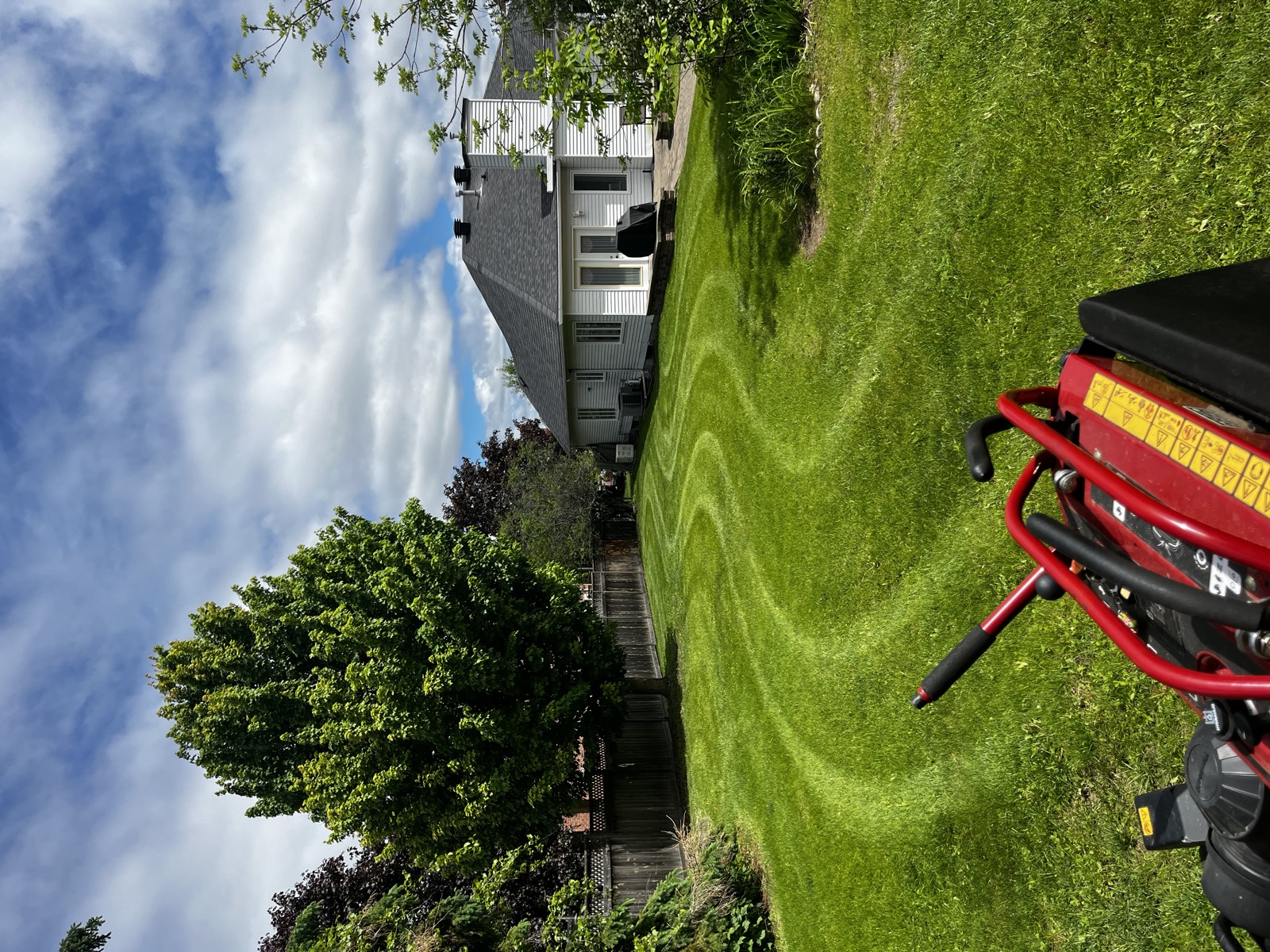 Curved striped lawn behind a riding mower